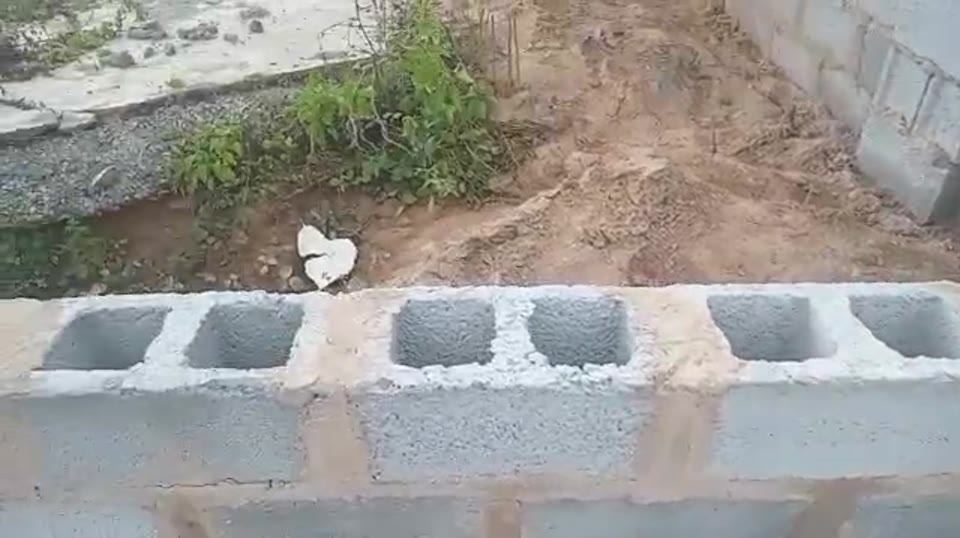 Site team working along a blockwork boundary wall