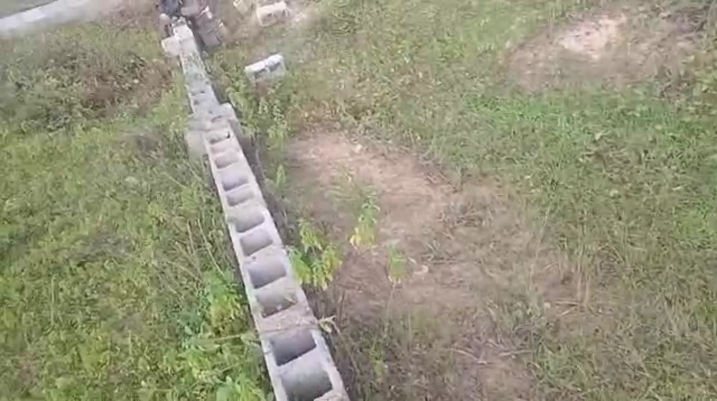 A completed blockwork boundary fence running across grass on a sloping site