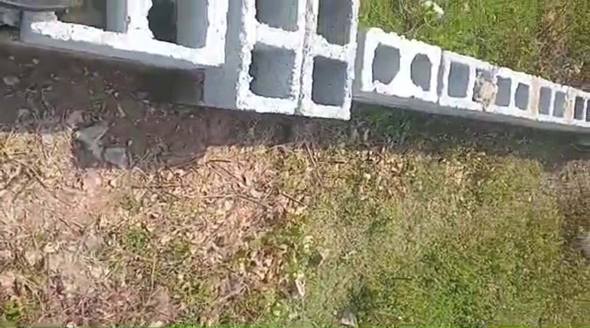 Hollow-block columns and wall course beside a building under scaffolding